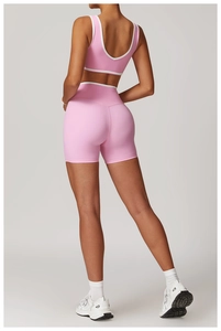 Detail view of the back of pink high waist yoga set with white contrast piping details