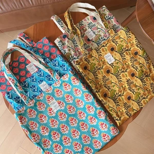 Close-up of vintage Indian floral print tote bags on a round wooden table