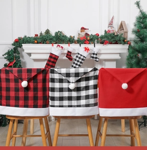 Close-up of festive Christmas chair covers in red and plaid patterns with white pom-poms