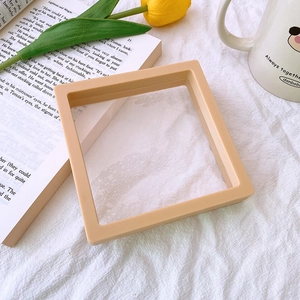 Beige PE film floating jewelry display box set on white fabric with a yellow tulip