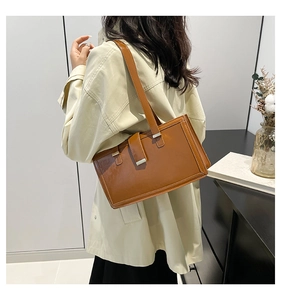 Side view of a brown vintage leather shoulder bag worn by a model in a minimalist room
