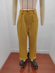 Detail der hoch taillierten senfgelben Cordhose mit Knopfverschluss und Textur