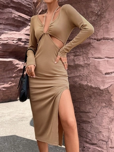 Elegante vestido midi de punto camel con aberturas en cintura y abertura lateral sobre rocas