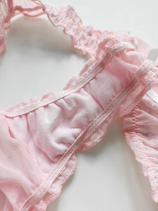 Macro detail of pink mesh thong showing ruffle trim and intricate lace sewing texture