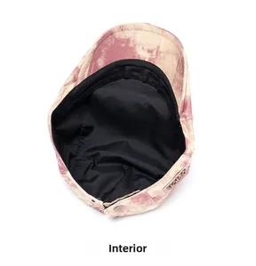 Detail of vintage tie-dye flat cap interior featuring black lining and adjustable snap button