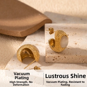 Detail of gold C-shaped earrings with textured surface and oval white opal stones