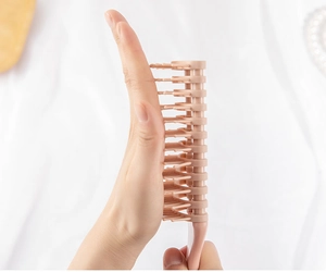 Detailed side view of pink vented hairbrush showing ergonomic design and curved structure