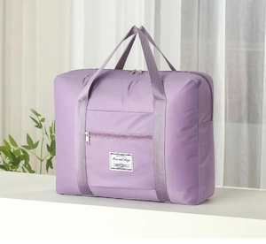 Detail of deep purple travel bag showing sturdy dual handles and front zipper pocket
