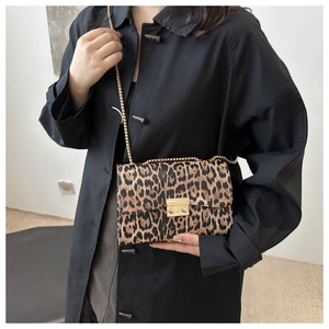 Detail der Schultertasche mit Leopardenmuster, goldener Kette und Metallverschluss