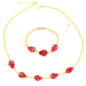 Detail of beaded necklace and strawberry pendant with pink cord bracelet set on white background