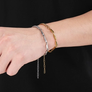 Close-up of gold and silver cuban chain bracelets with geometric facets and extender