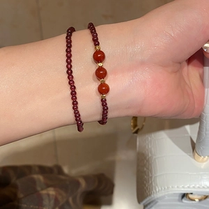 Close-up of double-layered garnet and strawberry crystal bracelets on a wrist
