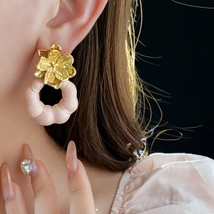 Gros plan d'une boucle d'oreille fleur vintage avec pendentif rose sur un mannequin