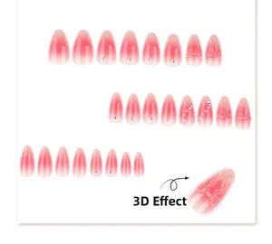 Macro detail of almond press-on nails with 3D resin bows, pearls, and pink blush gradient