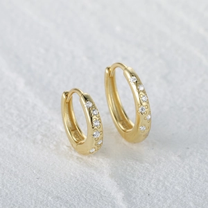 Close-up of golden S925 silver hoop earrings with floral engraving and zircon stones