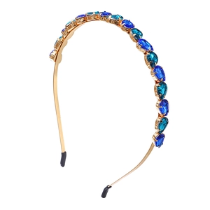Detail view of water drop blue gemstones set on a gold metal frame headband