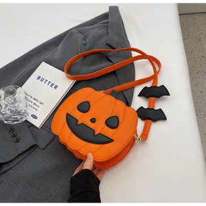 Detail view of pumpkin-shaped crossbody bag with bat wings and a black ghost face