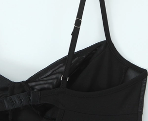Detail view of adjustable spaghetti straps and mesh stitching on the black dress