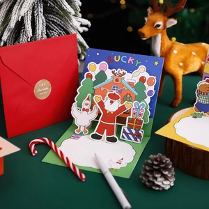 3D pop-up Christmas card with red envelope featuring Santa Claus and reindeer scene