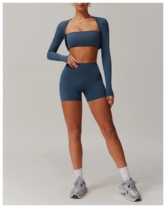 Three-piece yoga set including blue sports bra, long sleeve shrug and high waist shorts