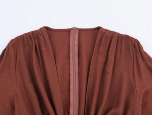 Close-up of invisible zipper and pleated back collar on a brown long sleeve V-neck dress