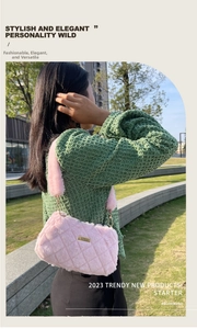 Close-up of pink plush shoulder bag with diamond quilting and gold chain strap