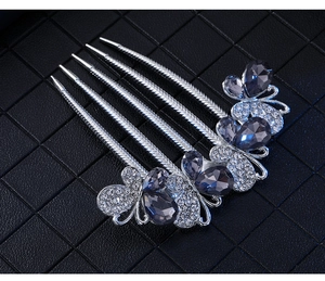 Detailed close-up of a silver hair comb with deep blue teardrop rhinestones
