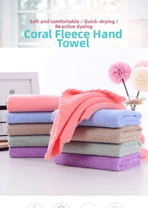 Close-up of soft coral fleece hand towels in various pastel colors stacked on a windowsill
