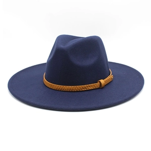 Detail of dark blue wide brim fedora with a brown woven leather hatband and flat brim