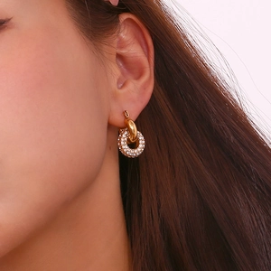 Close-up of 18K gold plated double hoop earrings with pavé crystals on a female model