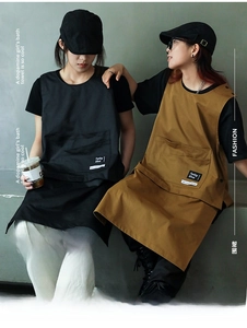 Detail view of durable canvas work apron featuring large utility pockets and snap buttons