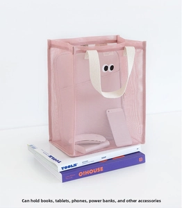 Pink mesh tote bag with eye decor showing spacious storage for books and devices
