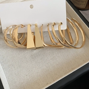 Detailed view of assorted gold geometric hoop earrings set on a white display card