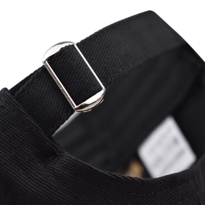 Detailed macro view of the black cotton baseball cap with adjustable silver metal buckle
