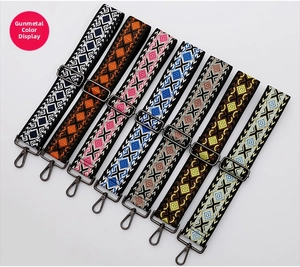 Close-up of seven ethnic embroidered bag straps with gunmetal clips and geometric diamond patterns
