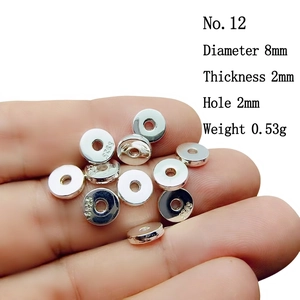 Macro detail of 8mm S925 sterling silver spacer beads with engraved logo for DIY jewelry