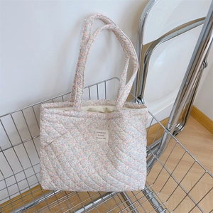 Détail du sac cabas matelassé à fleurs avec rembourrage et étiquette en tissu
