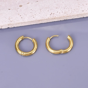 Polished gold stainless steel hoop earrings with secure snap closure on a stone surface