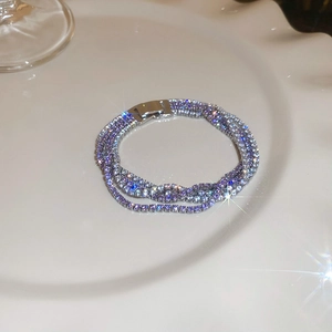Makroaufnahme von mehrschichtigem Zirkonia-Armband mit Silberverschluss auf weißem Teller
