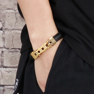 Detailed view of men's braided leather bracelet with golden stainless steel buckle clasp