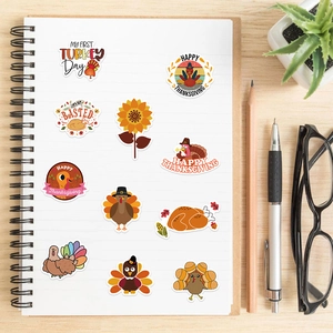 Close-up of Thanksgiving turkey stickers in a notebook on a wooden desk with stationery