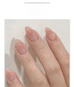 Detail of nude pink almond press-on nails with a glossy translucent jelly texture