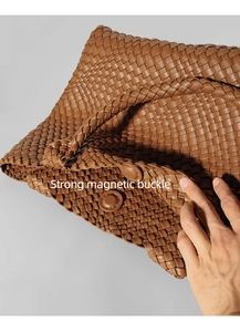 Close-up of woven brown leather handbag featuring a strong magnetic buckle closure