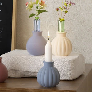Detail of ribbed ceramic candle holder and vase in pastel tones for Nordic home decor