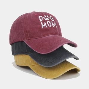 Close-up of embroidered DOG MOM text on washed cotton baseball caps in three colors