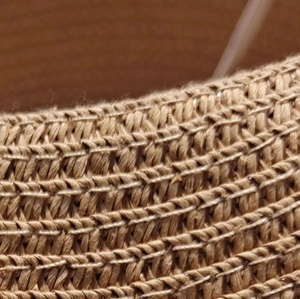 Macro shot of detailed straw weave pattern with silver sequins on women's sun hat