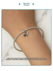 Close-up of s925 silver dragonfly charm bracelet with colorful gemstone wings on mesh chain
