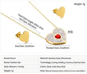 Detailed view of heart necklace and earrings set with red zircon and crystal accents