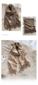 Detailed view of soft dark brown and beige cashmere-feel scarves with fringe tassels