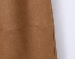 Detail view of caramel brown faux suede skirt featuring a reinforced side seam and stitching
